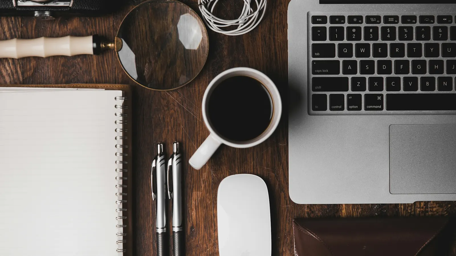 Laptop, notebook and coffee on a desk ready for website planning