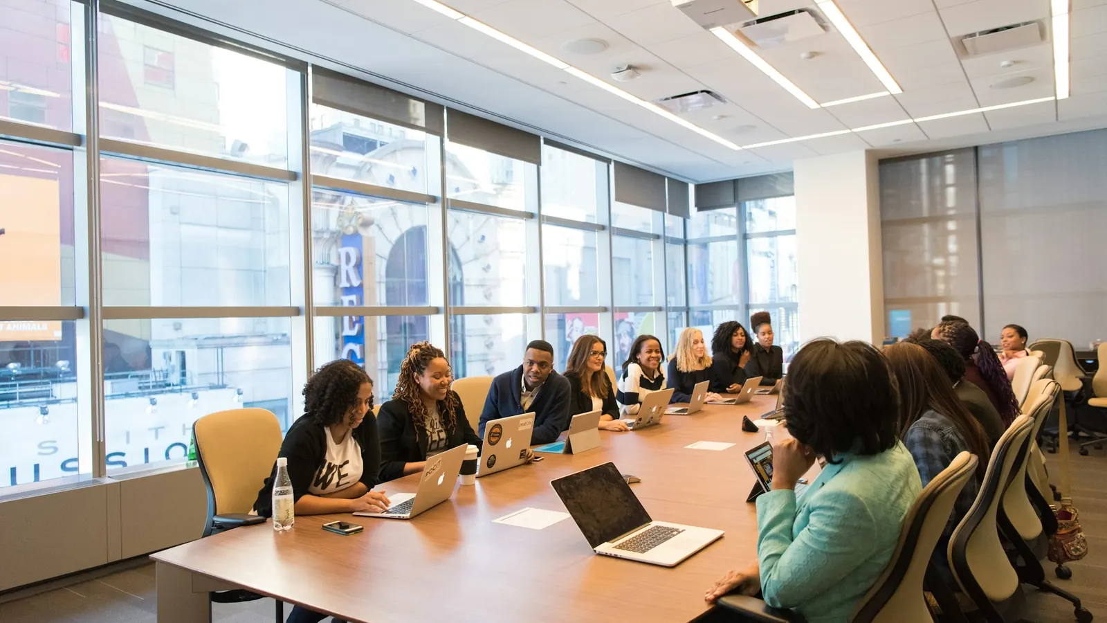 Marketing team meeting around a conference table with laptops