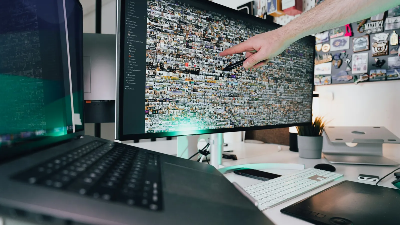 Person pointing at a computer screen while reviewing a marketing plan